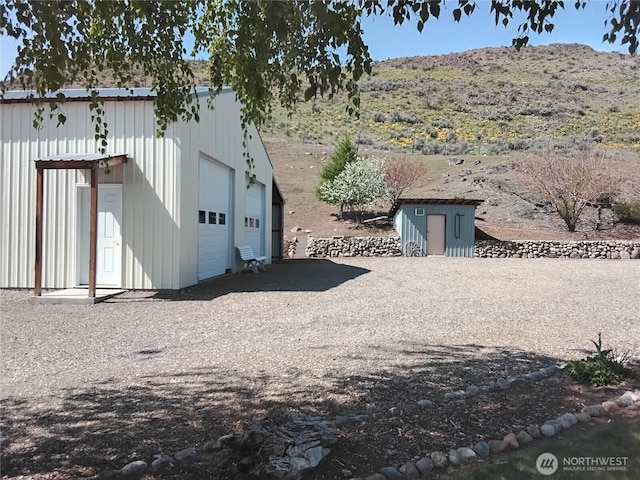 exterior space with a garage and an outbuilding