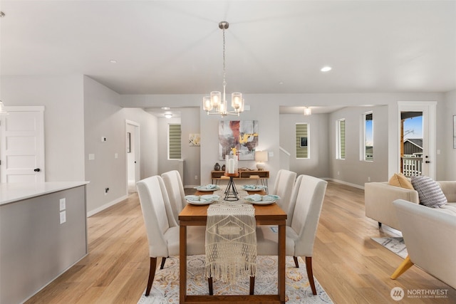 dining area with baseboards, recessed lighting, a notable chandelier, and light wood-style floors