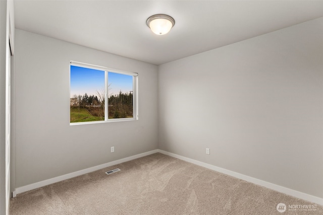 unfurnished room featuring baseboards, visible vents, and carpet floors