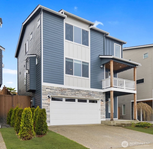 modern home featuring stone siding, concrete driveway, an attached garage, a balcony, and board and batten siding