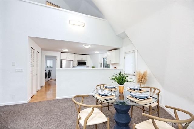 6455 NE Brigham Rd, Bainbridge Island, WA 98110 - dining room featuring light carpet, baseboards, and high vaulted ceiling