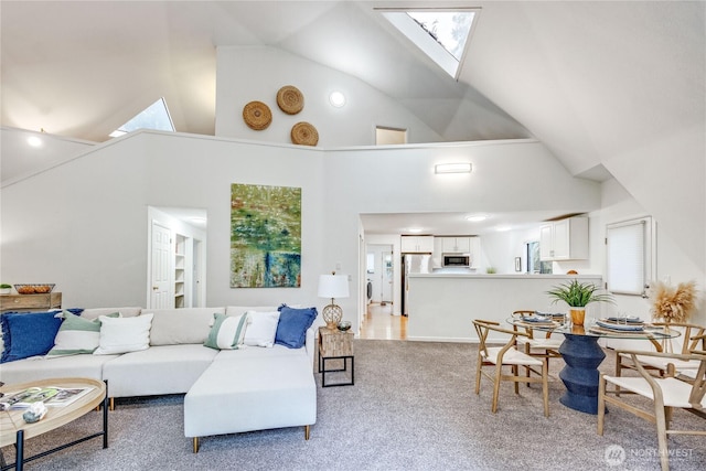 6455 NE Brigham Rd, Bainbridge Island, WA 98110 - living room featuring a skylight, high vaulted ceiling, and light carpet