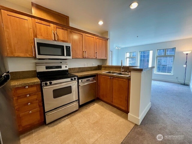 123 Queen Anne Ave N Unit 405, Seattle, WA 98109 - kitchen featuring brown cabinetry, stainless steel appliances, and a sink