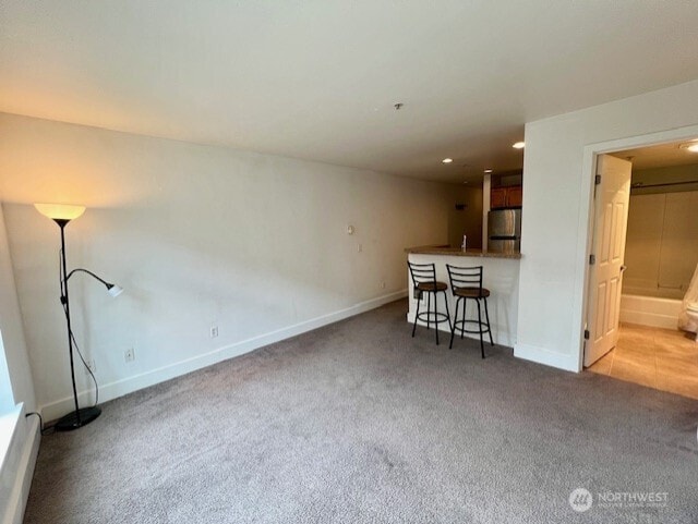 123 Queen Anne Ave N Unit 405, Seattle, WA 98109 - unfurnished living room featuring carpet flooring, baseboards, and a baseboard radiator
