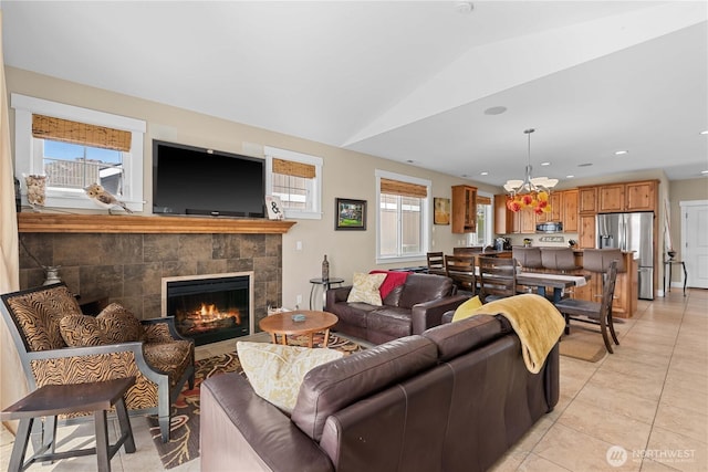 living room featuring vaulted ceiling, recessed lighting, light tile patterned floors, a chandelier, and a tile fireplace