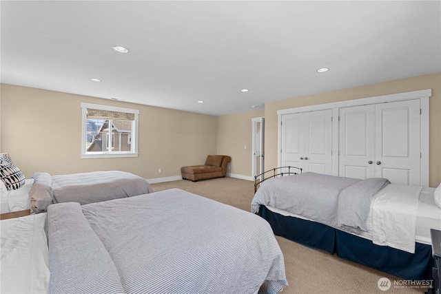 bedroom featuring light colored carpet, multiple closets, recessed lighting, and baseboards