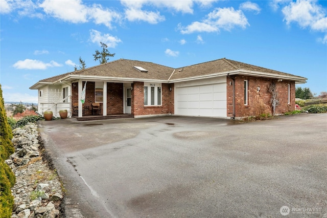 view of front of property with brick siding, driveway, and a garage