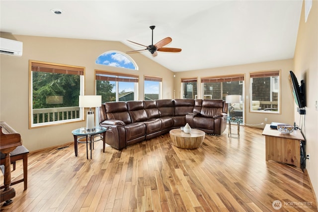 living room with light wood-type flooring, a wall unit AC, lofted ceiling, and a ceiling fan