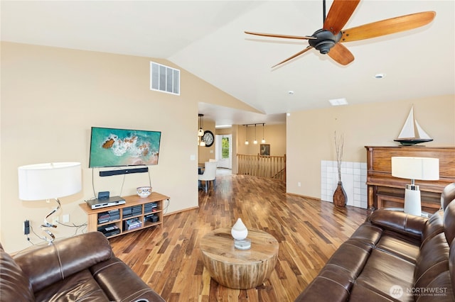 living room with visible vents, wood finished floors, lofted ceiling, and a ceiling fan