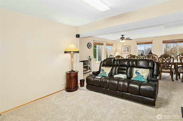 living room with plenty of natural light, baseboards, carpet flooring, and a ceiling fan