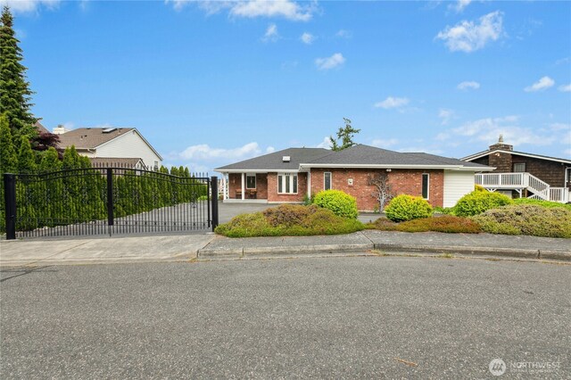 822 SW Fairhaven Ave, Oak Harbor, WA 98277 - view of front of house with driveway, brick siding, and a gate