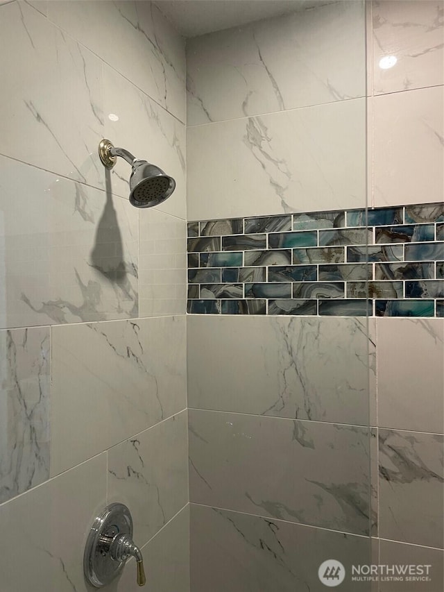 interior details featuring tiled shower