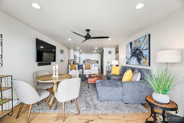living room featuring light wood-type flooring, ceiling fan, and recessed lighting