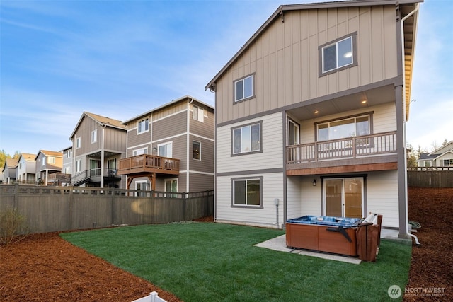 33140 Glacier Ave SE, Black Diamond, WA 98010 - rear view of house with a balcony, a fenced backyard, a hot tub, board and batten siding, and a lawn