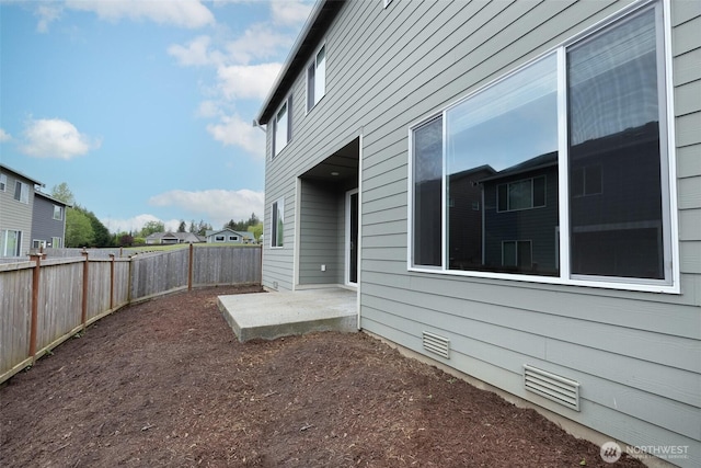 view of side of home featuring a patio and a fenced backyard