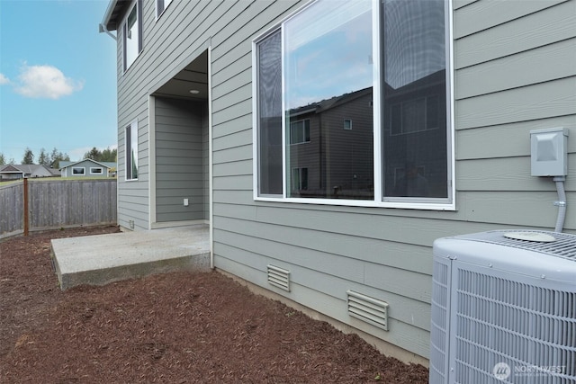 view of home's exterior with a patio, central air condition unit, and fence