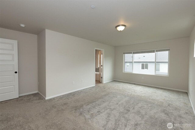 carpeted empty room with baseboards