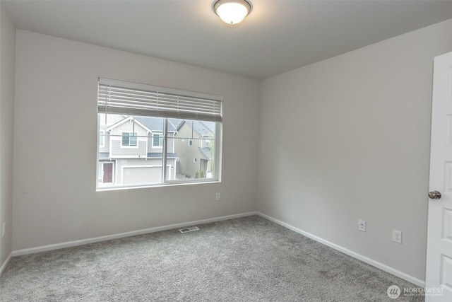 carpeted spare room with baseboards and visible vents