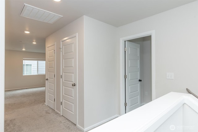 hallway featuring recessed lighting, visible vents, and light carpet