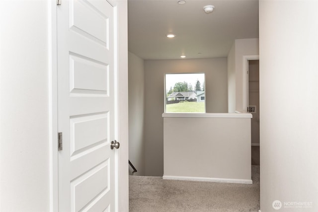 hallway with recessed lighting, carpet, and an upstairs landing