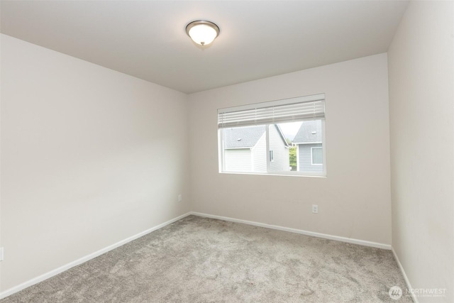 carpeted spare room featuring baseboards