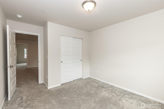 unfurnished bedroom with carpet floors, baseboards, and a closet
