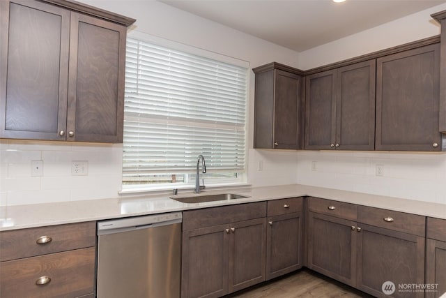kitchen with dark brown cabinetry, tasteful backsplash, a sink, light wood-style flooring, and dishwasher