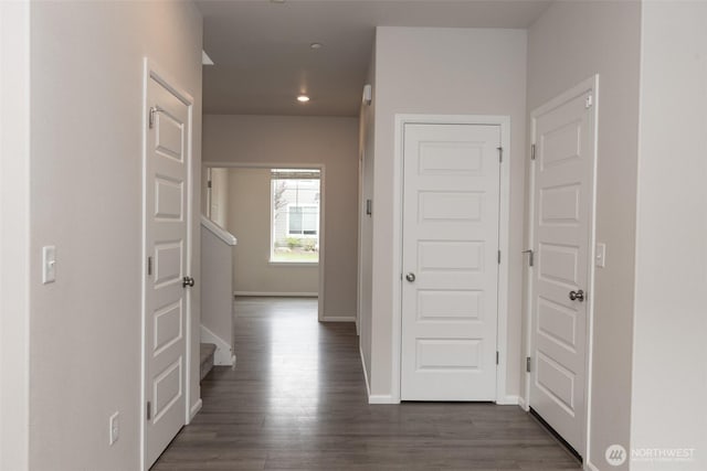 corridor with baseboards, recessed lighting, and dark wood-type flooring