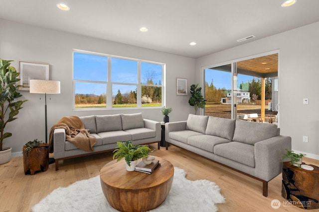 living area featuring baseboards, wood finished floors, visible vents, and recessed lighting