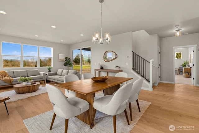 dining room featuring light wood-style flooring, an inviting chandelier, recessed lighting, and stairway