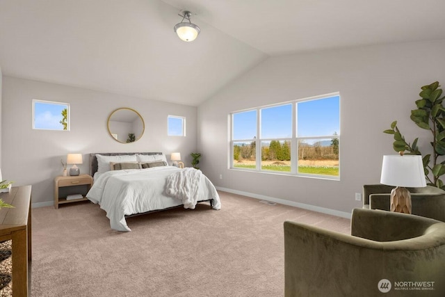 bedroom with vaulted ceiling, light colored carpet, and multiple windows