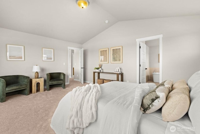bedroom featuring vaulted ceiling, ensuite bath, and carpet