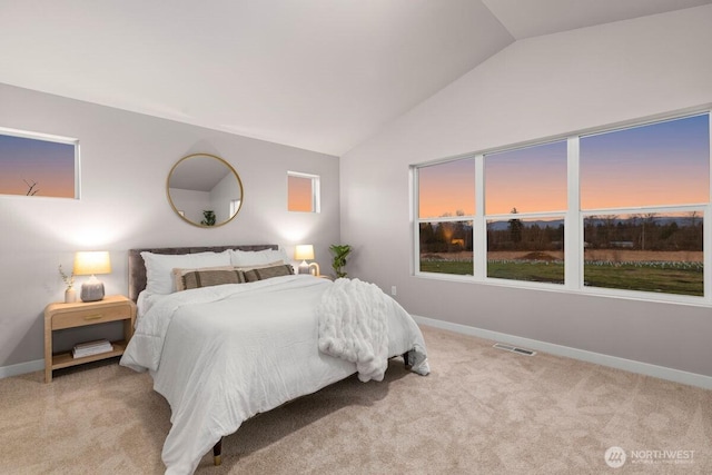 bedroom featuring lofted ceiling, visible vents, baseboards, and carpet