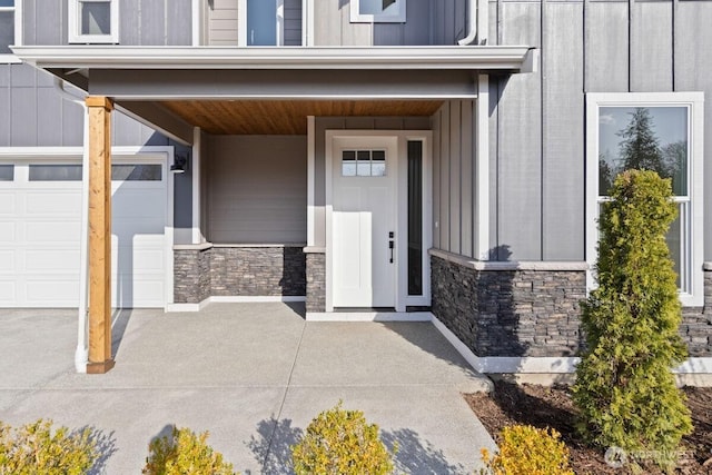 doorway to property with stone siding, a porch, board and batten siding, and a garage