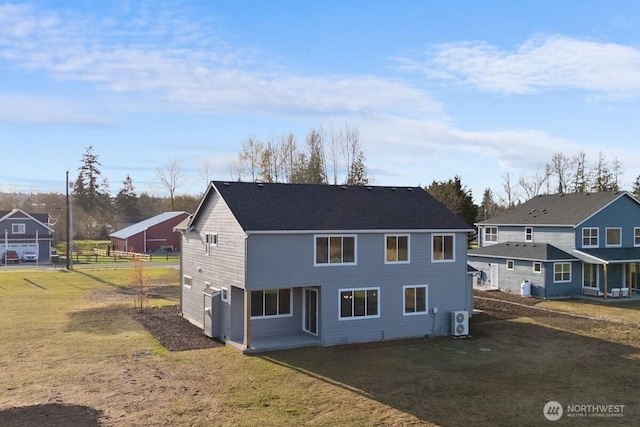 back of property with a residential view, a lawn, and fence