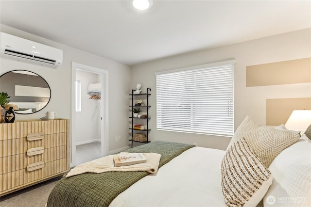 bedroom featuring baseboards, a wall mounted air conditioner, carpet, and a walk in closet