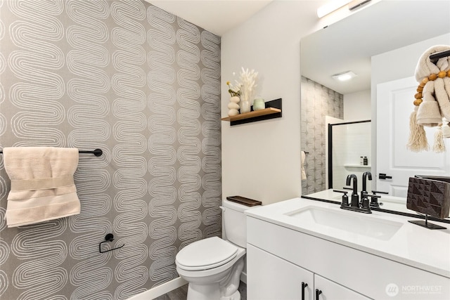 bathroom featuring walk in shower, toilet, and vanity