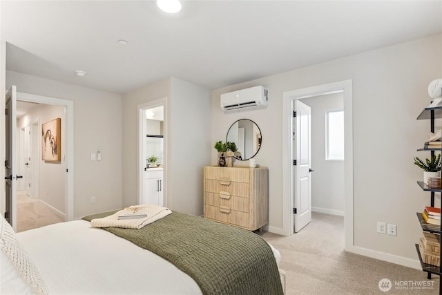 bedroom with ensuite bathroom, light carpet, an AC wall unit, and baseboards