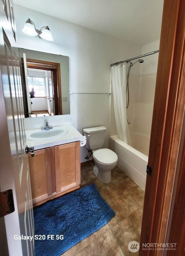 full bathroom featuring toilet, vanity, and shower / bath combo with shower curtain