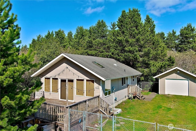 view of front of property with an outbuilding, fence, a detached garage, and a front yard