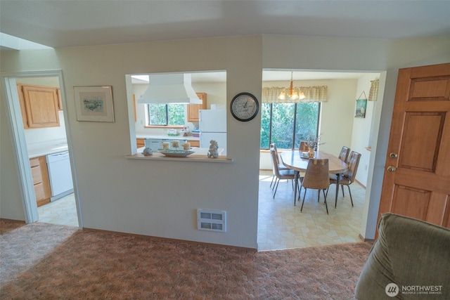 dining area with light carpet, a chandelier, and a wealth of natural light