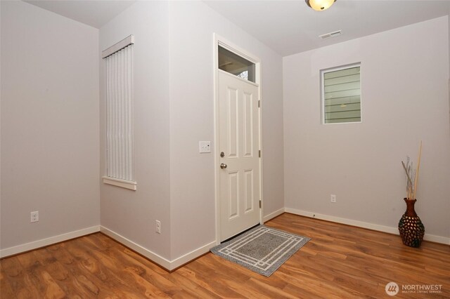 entryway featuring baseboards, visible vents, and wood finished floors