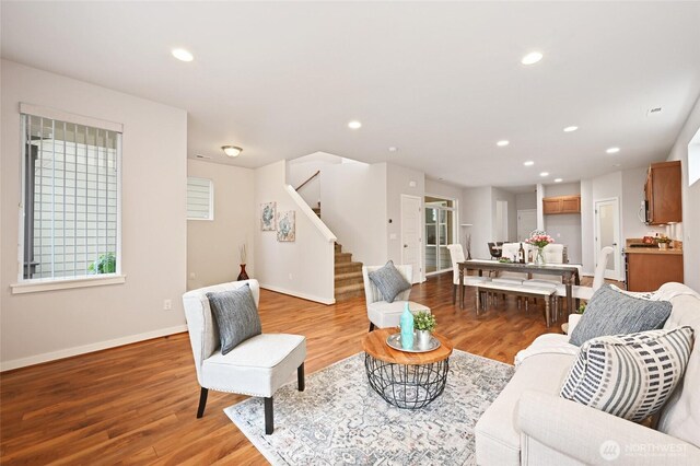living area with light wood-style flooring, stairway, and recessed lighting