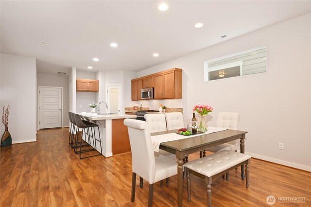 dining area featuring baseboards, visible vents, wood finished floors, and recessed lighting