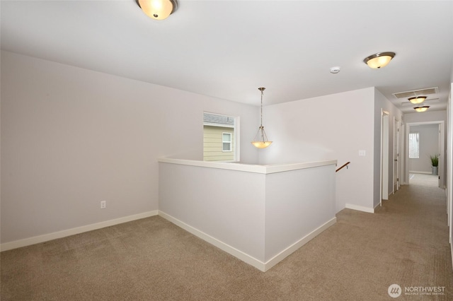 hallway with baseboards, an upstairs landing, visible vents, and light carpet