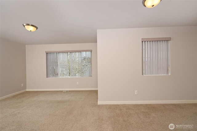 carpeted spare room with baseboards