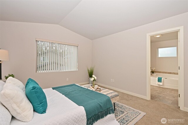 bedroom with baseboards, vaulted ceiling, carpet floors, and ensuite bath