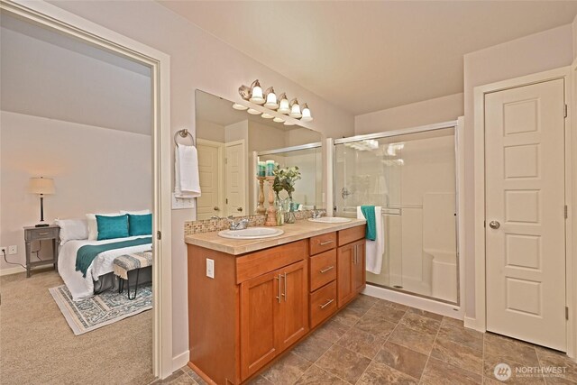 full bath with a stall shower, double vanity, and a sink