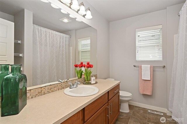 bathroom with baseboards, visible vents, toilet, and vanity