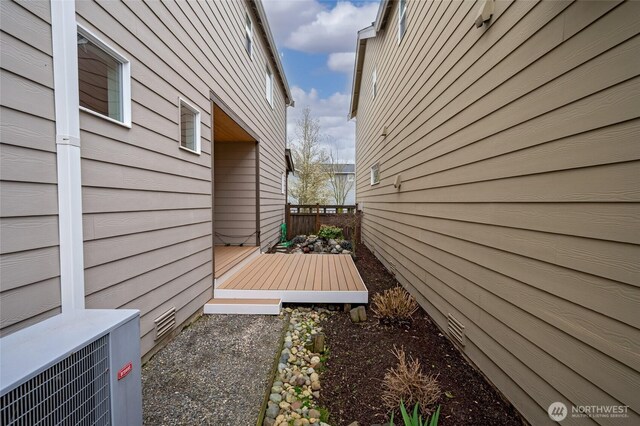view of side of home with central AC and a deck